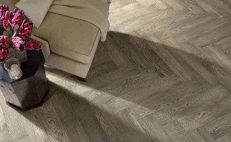 Herringbone hardwood floor with beige chair 